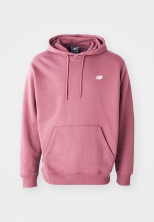 Kapucinfli särk tolmuroosa värviga, valmistatud pehmest kangast, ees oleva taskuga ja valge logoga rinnal. Klassikaline lõige ribakätistega.