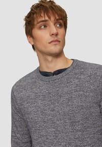 Strickpullover mit Rundhalsausschnitt in Marineblau mit strukturiertem Muster; verfügt über eine Knopfleiste und einen kontrastierenden dunklen Kragen. Weicher, mittelschwerer Stoff.