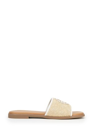 Beige geweven sandaal met witte rand en platte bruine zool, open teen en logodetail op de bovenste band, zijaanzicht.