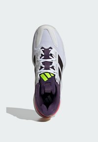 Hvide sportsko med mesh-materiale, lilla accenter og sorte striber. Har en neongrøn detalje og en tekstureret sål.