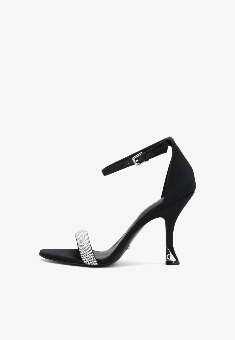 Sandalo nero con tacco alto in finitura scamosciata, dotato di una larga fascia decorata con strass e di un sottile cinturino per la caviglia.