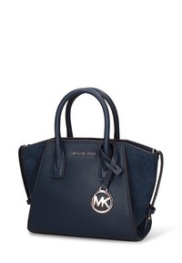 Marineblauwe handtas gemaakt van gestructureerd leer en suède, met dubbele handvatten, een afneembare schouderriem en een zilveren MK-logo als accent.