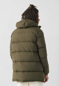 Olijfgroen pufferjack met een capuchon, met horizontaal doorgestikte secties, een ritssluiting aan de voorkant en een iets relaxte pasvorm.