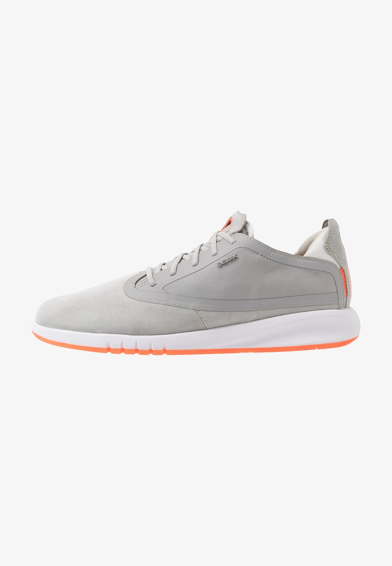 Gray suede athletic shoes with a low profile, featuring a white sole with an orange accent, and a streamlined design with laces.