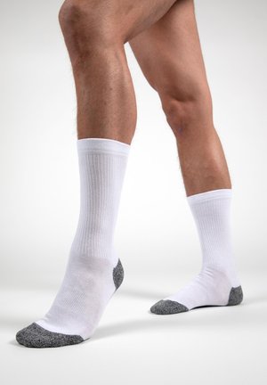 Chaussettes blanches en coton avec texture côtelée, présentant des accents gris au talon et aux orteils. Longueur cheville, conçues pour le confort et la durabilité.
