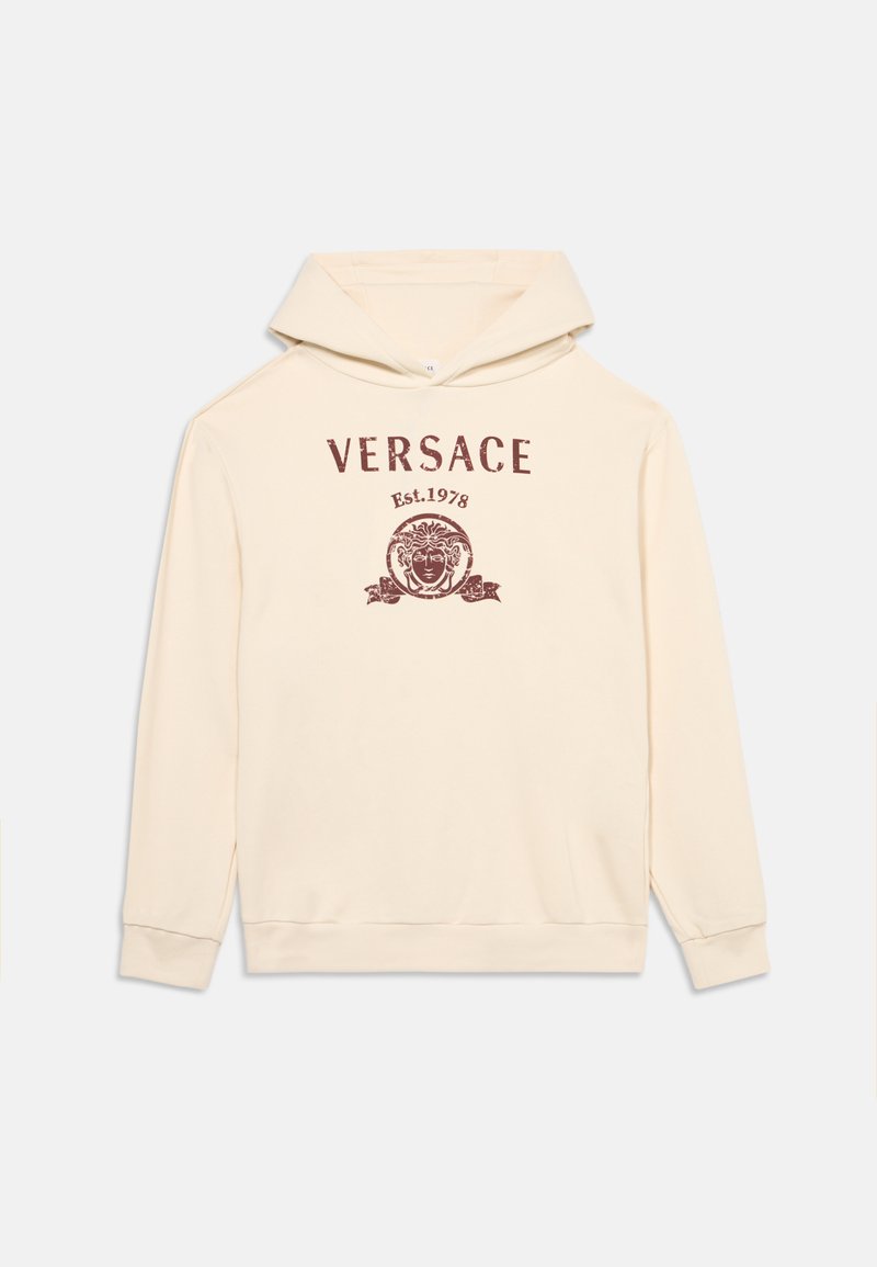 Φούτερ Versace σε κρεμ απόχρωση με κουκούλα και λογότυπο μπροστά που απεικονίζει το κεφάλι της Μέδουσας και το κείμενο "VERSACE Est. 1978" σε σκούρο κόκκινο χρώμα.