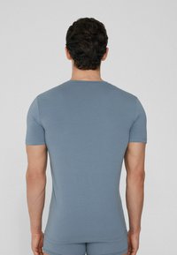 Camiseta azul ajustada de Manga Corta, hecha de una tela suave, con un cuello redondo y un diseño sin costuras en los hombros y el dobladillo.