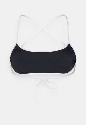 Haut de bikini noir avec bord blanc, featuring des bretelles croisées dans le dos et un détail de nœud à l'avant. Tissu lisse avec des côtés froncés pour une texture supplémentaire.