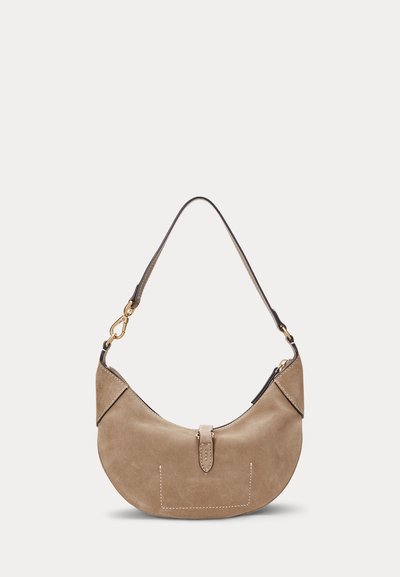 Taupe semišová kabelka v tvare polmesiaca so zlatým zapínaním a čiernym koženým remienkom na jednoduchom svetlom pozadí.