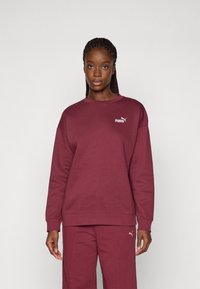 Brun sweatshirt med en rund halsudskæring, lange ærmer og et lille hvidt Puma-logo på brystet. Fremstillet af blødt stof med en tekstureret finish.