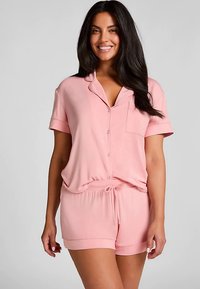 Roze pyjama set met korte mouwen, bestaande uit een knoopsluitend shirt met een zakje en korte broek met trekkoord, gemaakt van zachte, lichtgewicht stof.
