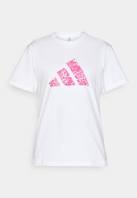 Bílý bavlněný tričko s krátkým rukávem, které na přední straně zdobí růžový abstraktní design loga Adidas.