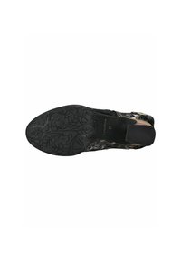 Suela de zapato negra con un intrincado patrón floral, que presenta una superficie texturizada. El material parece ser de tipo goma con un tacón liso.