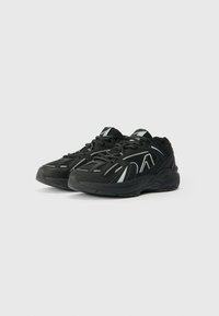 Pantofi sport negri cu o parte superioară texturată, având accente reflectorizante argintii și o talpă moale. Design cu șireturi și zone din plasă respirabilă.