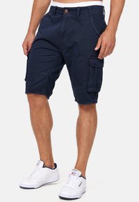 Shorts de marine en coton, dotés de plusieurs poches sur les côtés, d'une taille ajustée avec une fermeture à bouton et d'une coupe droite.