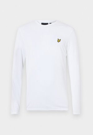 Camisa blanca de manga larga hecha de algodón que presenta un pequeño logo amarillo bordado en el lado izquierdo del pecho. Diseño simple con escote redondo.