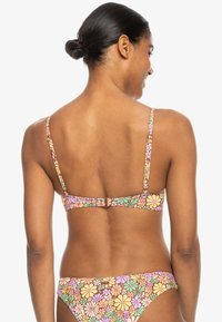 Top de bikini multicolor con patrón floral, tirantes ajustables y cierre con gancho en la parte posterior. Elaborado con un tejido liso y elástico.