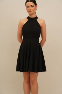 Fekete ujjatlan ruha magas nyakkal, testhezálló felsőrésszel és szoknyarésze bővülő, sima anyagból, minimális varrással.