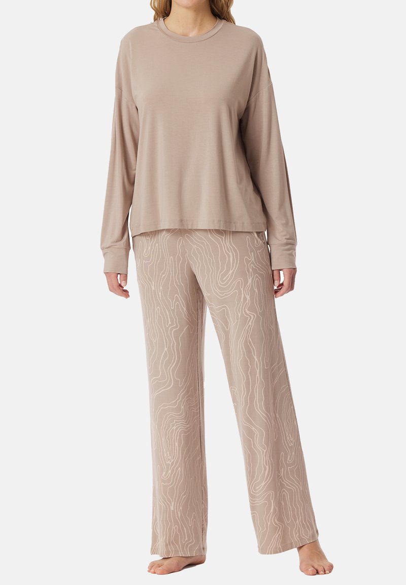 Long-sleeve beige top paired with flowy beige pants featuring a textured light-colored wavy line pattern. Comfortable knit material.