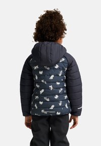 Vadderad jacka med en mörkblå huva och överkropp; mönstrad med ljusa tecknade figurer på nedre ryggen och sidorna.