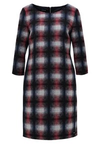 Robe à carreaux à manches longues, présentant un motif noir, rouge et blanc. Fabriquée en tissu texturé, avec un col rond et une fermeture éclair au dos.