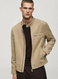 Beige suede jacket with a stand collar, front zipper, and side pockets. Features a slim fit and minimalistic design. Brown knit underlayer.