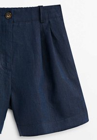 Shorts en lin bleu foncé avec un devant plissé, une fermeture à un seul bouton marron et une texture lisse pour un look décontracté.