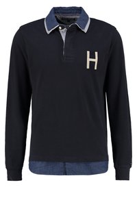 Polo manches longues bleu marine avec col bleu contrastant, patte de boutonnage et lettre beige "H" brodée sur la poitrine.