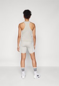 Lys gr�å tanktop og shorts med hvite detaljer, laget av glatt, elastisk materiale. Har en racerback-design og matchende sokker.