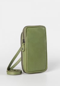Green leather pouch with a smooth texture, rectangular shape, zip closure, and adjustable strap. Minimalist design, clean lines.