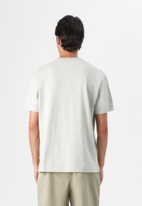 Graues T-Shirt mit kurzen Ärmeln aus weichem Stoff, mit Rundhalsausschnitt und lässiger Passform, von hinten gezeigt, ohne sichtbare Muster oder Logos.