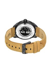 Montre à quartz avec un boîtier en acier inoxydable noir, dos transparent affichant un logo d'arbre, et un bracelet en suède brun avec une boucle en métal noir.