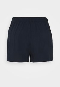 Shorts décontractés noirs à taille élastique avec un design simple et sans poches visibles, présentés sur un fond uni.