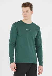 Langärmliges grünes Shirt aus strukturiertem Material mit horizontalen Streifen und runder Halslinie. Mit "ENDURANCE"-Logo auf der Brust.