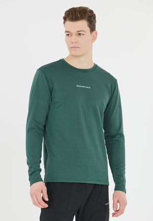Långärmad grön skjorta gjord av texturerat material med horisontella ränder och rundad halsringning. Har "ENDURANCE"-logotypen på bröstet.