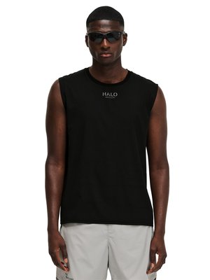 Mężczyzna w czarnej koszulce bez rękawów z napisem "HALO" i szarych szortach, stoi prosto na białym tle.