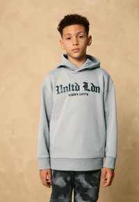 Felpa con cappuccio azzurro chiaro con stampa frontale che riporta "United Ldn 51.5229'N 0.0777'W", dotata di tasca a marsupio e polsini a costine.