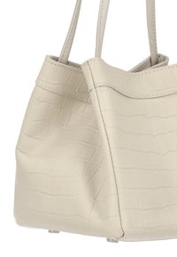 Tote bag van crèmekleurig imitatieleren met krokodillenstructuur, voorzien van twee stevige handvaten en een gestructureerde vorm, met een gladde textuur en minimale stiksels.