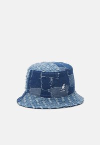 Cappello a secchiello in denim con un design patchwork, caratterizzato da diverse tonalità di blu e bordi sfilacciati. Include il logo Kangol sul lato.