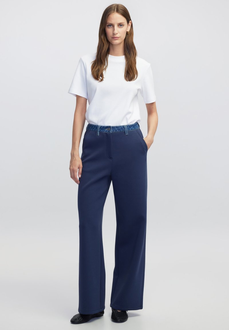 Marine brede-broek met een elastische tailleband in denimmateriaal. In combinatie met een effen witte T-shirt met korte mouwen. Glad stof en een relaxte pasvorm.