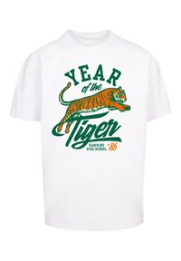 White cotton t-shirt featuring a graphic of a leaping tiger in orange and green text reading "YEAR of the Tiger HAWKINS HIGH SCHOOL '86."