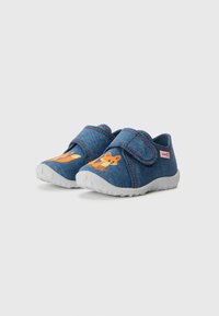 Jeans slip-on skor med grå gummisålar, med orange djurmönster på sidorna och justerbara kardborreband.
