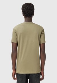 T-shirt a maniche corte, verde oliva, realizzato in cotone, con scollatura rotonda e vestibilità rilassata, caratterizzato da una texture liscia e dettagli minimi.