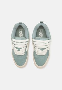 Light blue suede sneakers with white laces, rubber soles, and Vans logo on the tongue. Features a smooth texture and low-profile design.