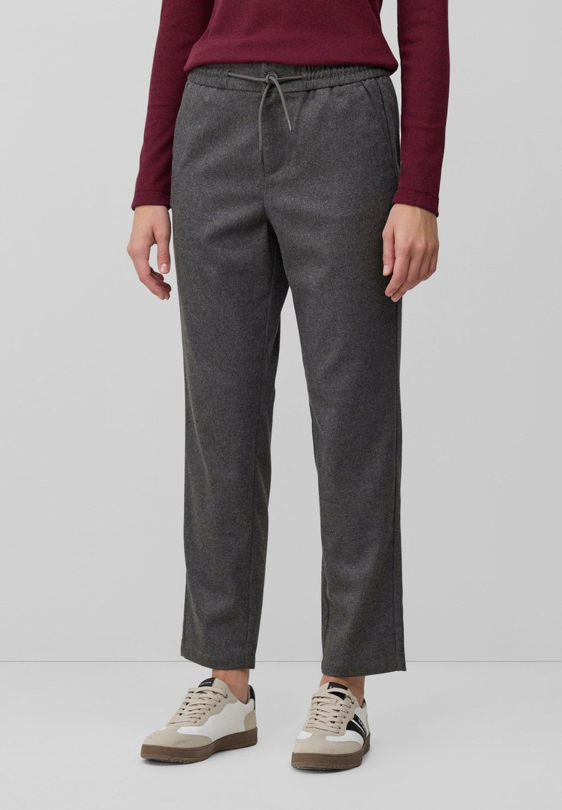 Graue, strukturierte, lässig geschnittene Hosen mit einem elastischen Bund und einer Kordelzugkante, kombiniert mit beige-weißen Sneakern.
