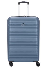 Valigia rigida di colore blu metallico con scanalature verticali, maniglia estensibile e quattro ruote girevoli a 360 gradi per una facile mobilità.