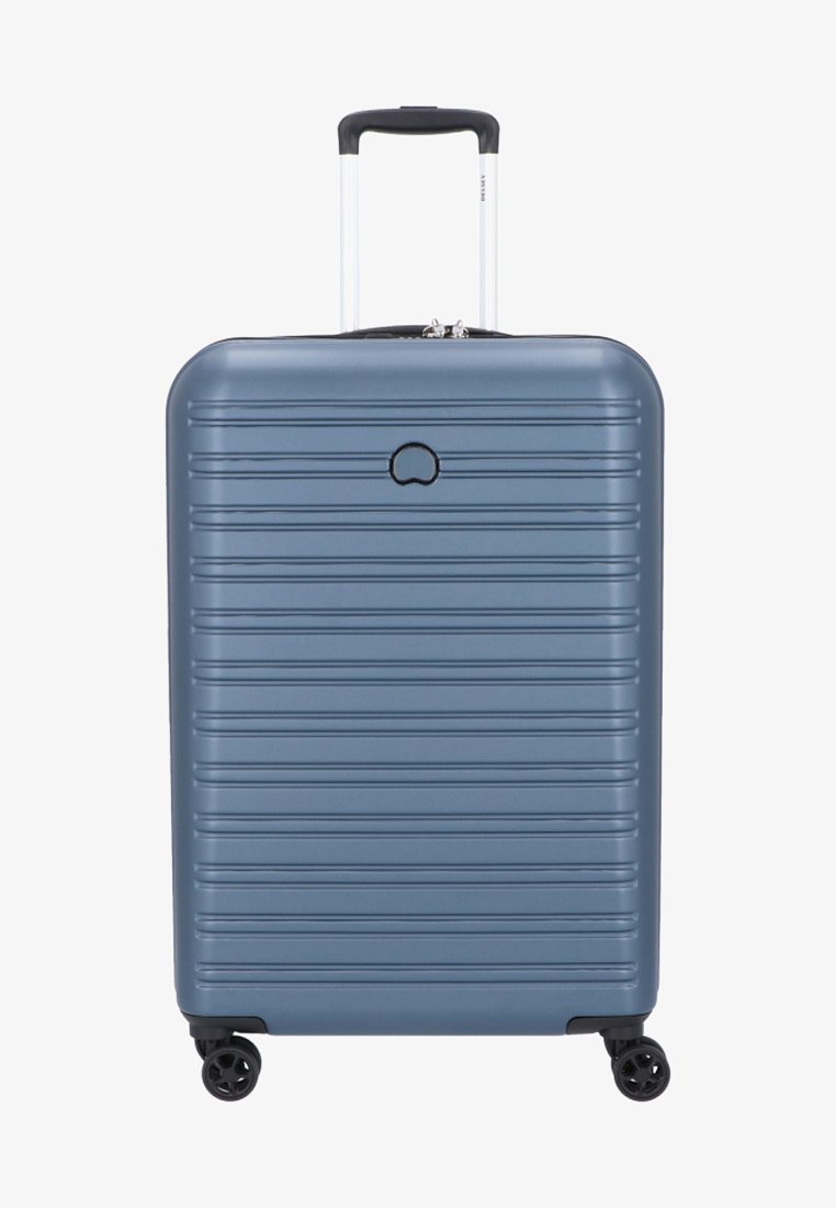 Valigia rigida di colore blu metallico con scanalature verticali, maniglia estensibile e quattro ruote girevoli a 360 gradi per una facile mobilità.
