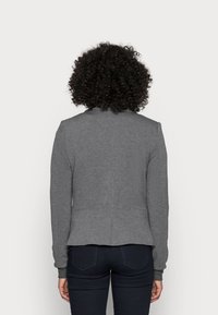 Grå sweatshirt med lång ärm, åtsittande design, mjukt tyg och detalj med söm bak. Inga synliga logotyper eller mönster.