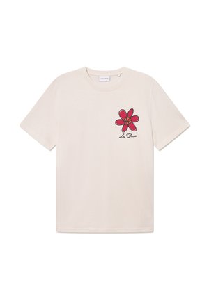 Beige cotton t-shirt featuring a red flower design on the left chest area with black outlines and text reading "Les Deux" beneath the flower.