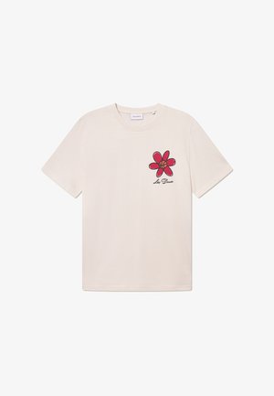 T-shirt en coton beige avec un design de fleur rouge sur la partie gauche de la poitrine, avec des contours noirs et le texte "Les Deux" en dessous de la fleur.